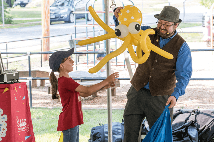 Wayne entertains at an outdoor library magic show.
