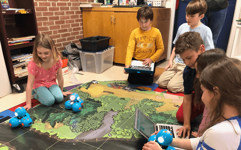 Kids programming a robot on an adventure map.